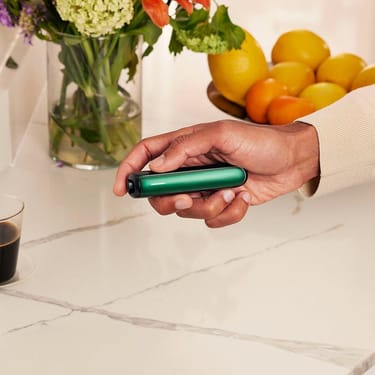 Ranka laiko Ploom AURA įrenginį su Amazon Green priekiniu dangteliu