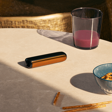 Ploom AURA priekinis dangtelis Mango Sorbet pritvirtintas prie įrenginio ant stalo
