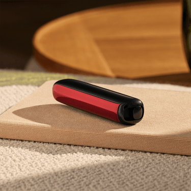 Ploom AURA priekinis dangtelis Lava Red padėtas ant stalo
